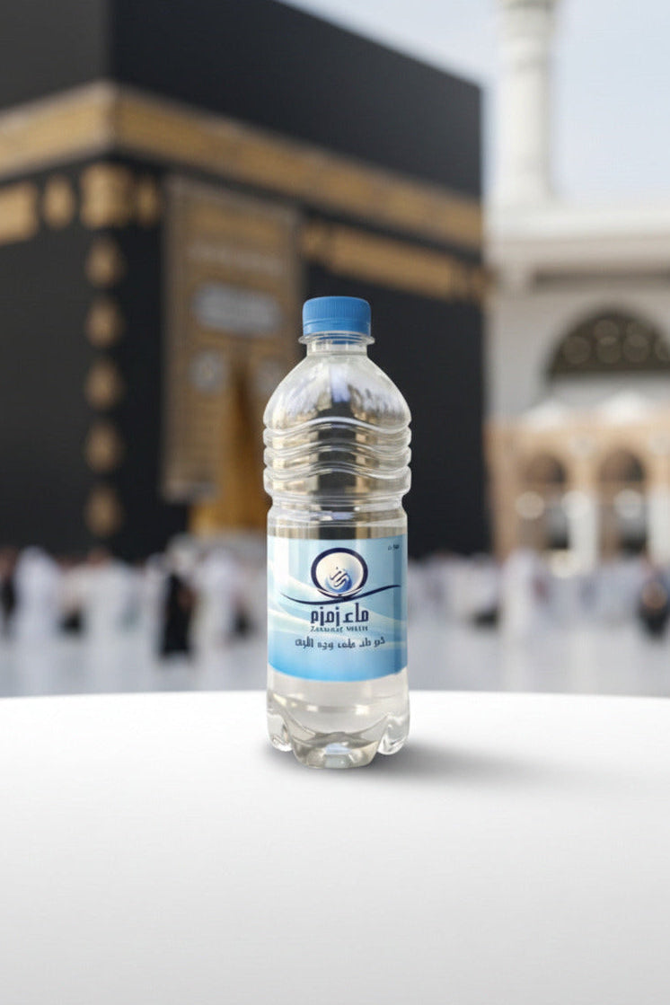 Bouteille d'eau de Zamzam authentique sur une table devant la Kaaba, source sacrée de la Mecque pour bienfaits spirituels et purification.