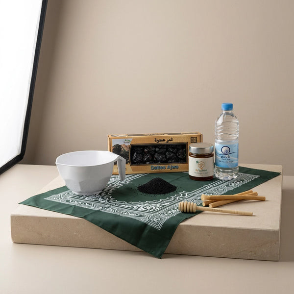 coffret sunnah essentiel avec un mudd, des siwak, une bouteille d'eau de zamzam, des dattes, un tapis de prière et un miel de nigelle avec sa cuillère 